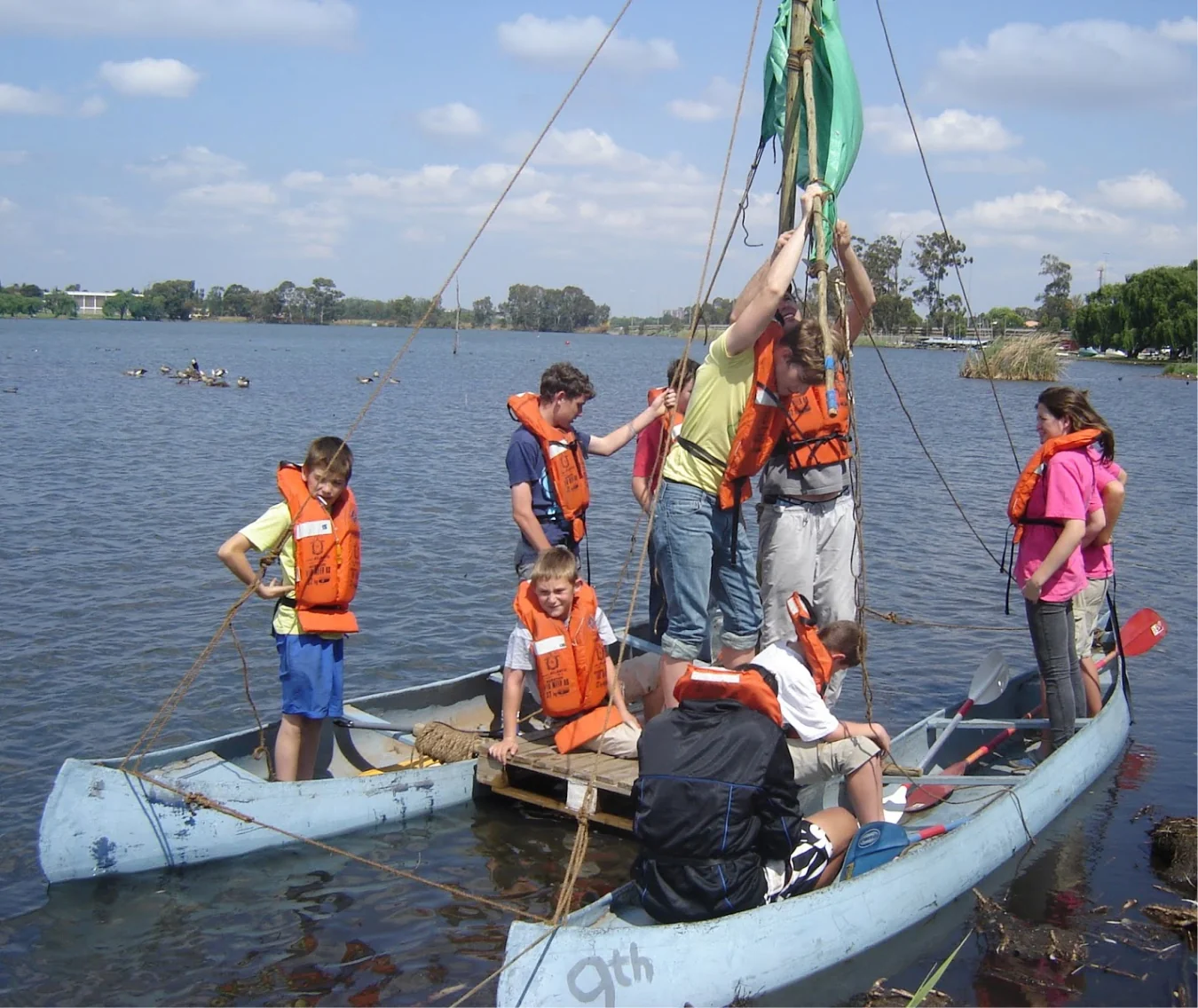 Un grupo construyendo un catamarán en el lago